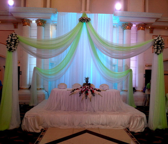 Свадебное оформление в Бакша Сарай. Композиция из белой и салатовой ткани. Стол украшен ладьей из живых цветов, а композиция украшена искусственными цветами.