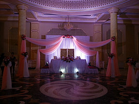 Композиция на президиум, стойки из живых цветов. Место жениха и невесты освещено прожекторами. В данной композиции использованы только живые цветы.